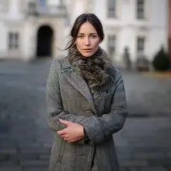 Elegancka kobieta w szarym płaszczu z futrzanym kołnierzem, idealnym okryciu wierzchnim na chłodne dni.
