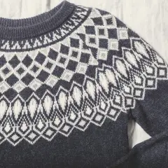Sfilcowany sweter z granatowej wełny z białym, geometrycznym wzorem. Idealny na chłodne dni.