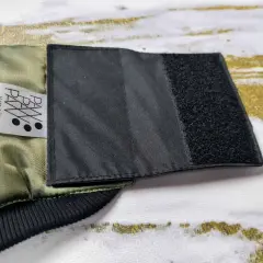 Fragment kurtki z naszytym rzepem, pokazujący, jak poszerzyć kurtkę. Metka "PAW Made in EU".
