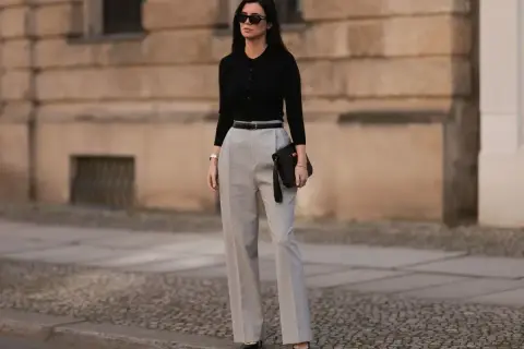 Eleganckie stylizacje na urodziny w domu: czarny sweterek, szerokie spodnie i kopertówka. Idealny zestaw na domowe przyjęcie.