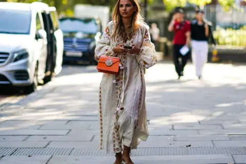 Kobieca sukienka boho z haftem i pomponami, idealnie komponuje się z delikatnymi sandałkami.