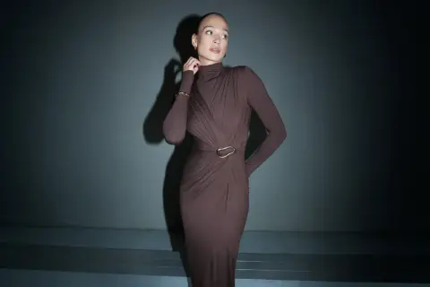 Elegancka, brązowa sukienka maxi z golfem i drapowaniem podkreśla sylwetkę. Długość sukienki do wzrostu modelki jest idealna.