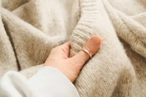 Miękki, beżowy sweter sfilcowany. Co zrobić, by przywrócić mu dawny wygląd? Delikatne pranie i pielęgnacja to klucz.