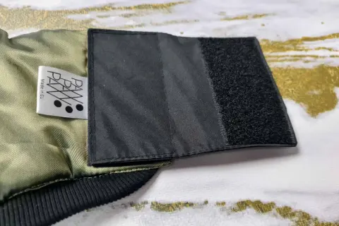 Fragment kurtki z naszytym rzepem, pokazujący, jak poszerzyć kurtkę. Metka "PAW Made in EU".