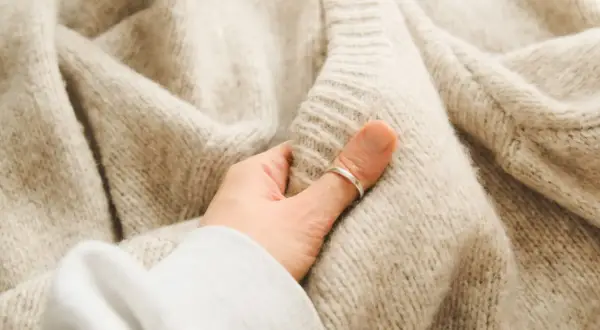 Miękki, beżowy sweter sfilcowany. Co zrobić, by przywrócić mu dawny wygląd? Delikatne pranie i pielęgnacja to klucz.